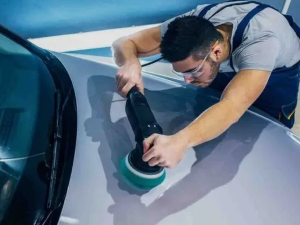 Profissional com politriz realizando polimento técnico no teto de um carro